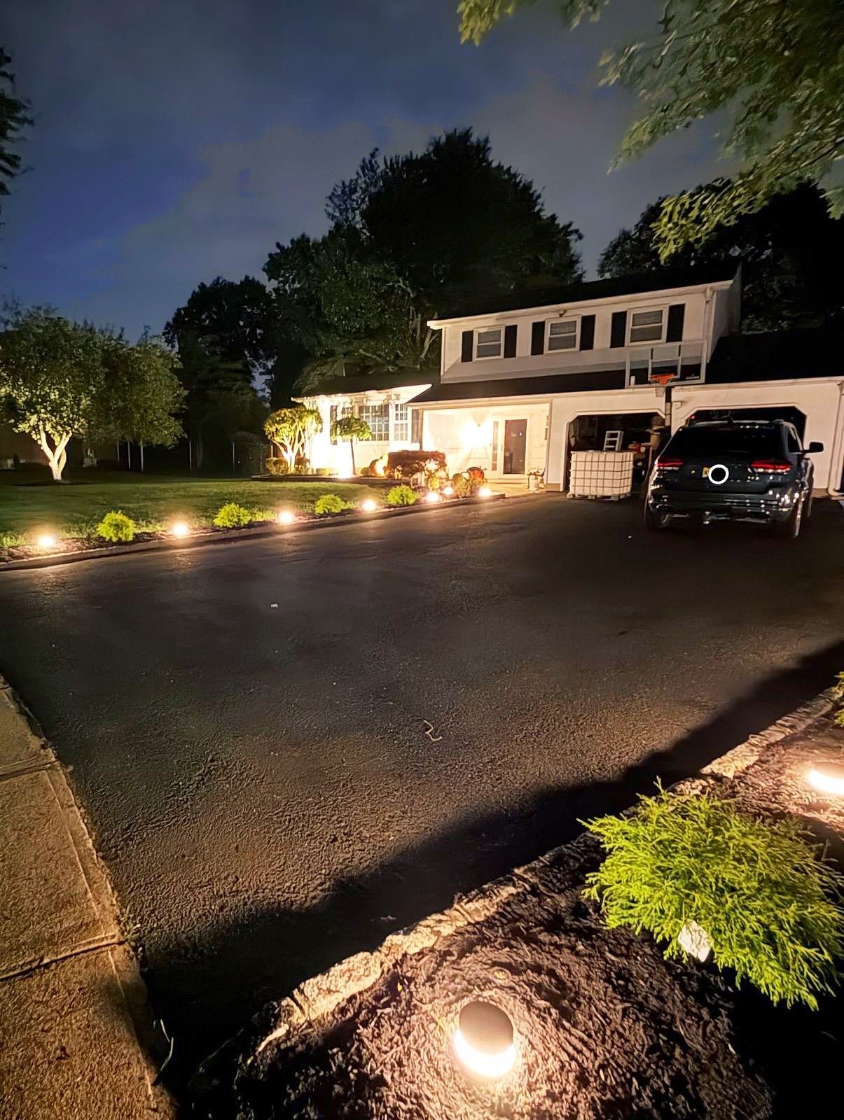 Long driveway lined with low voltage lights at night